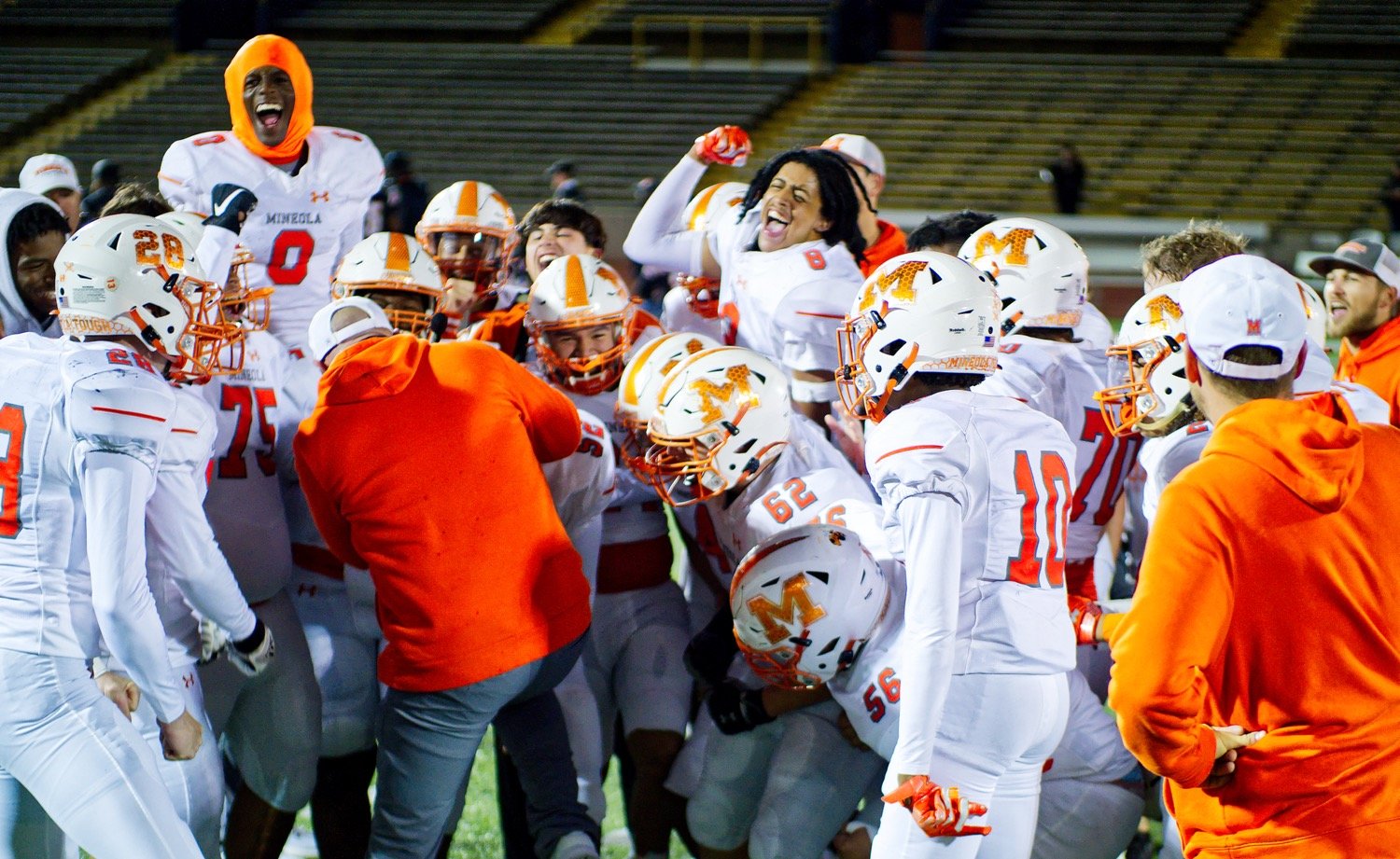 After completing a second-half comeback to clinch the fourth and final district playoff spot, Mineola players celebrate Saturday night in Commerce. [find more football photos]